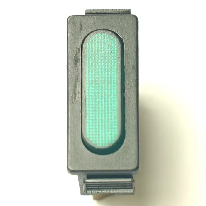 A top-view close-up of the V.4331 YELLOW MOMENTARY PUSH SWITCH, a rectangular black electronic component with a textured, illuminated green oval indicator, displayed on a white background. © 2025 1st-line.com