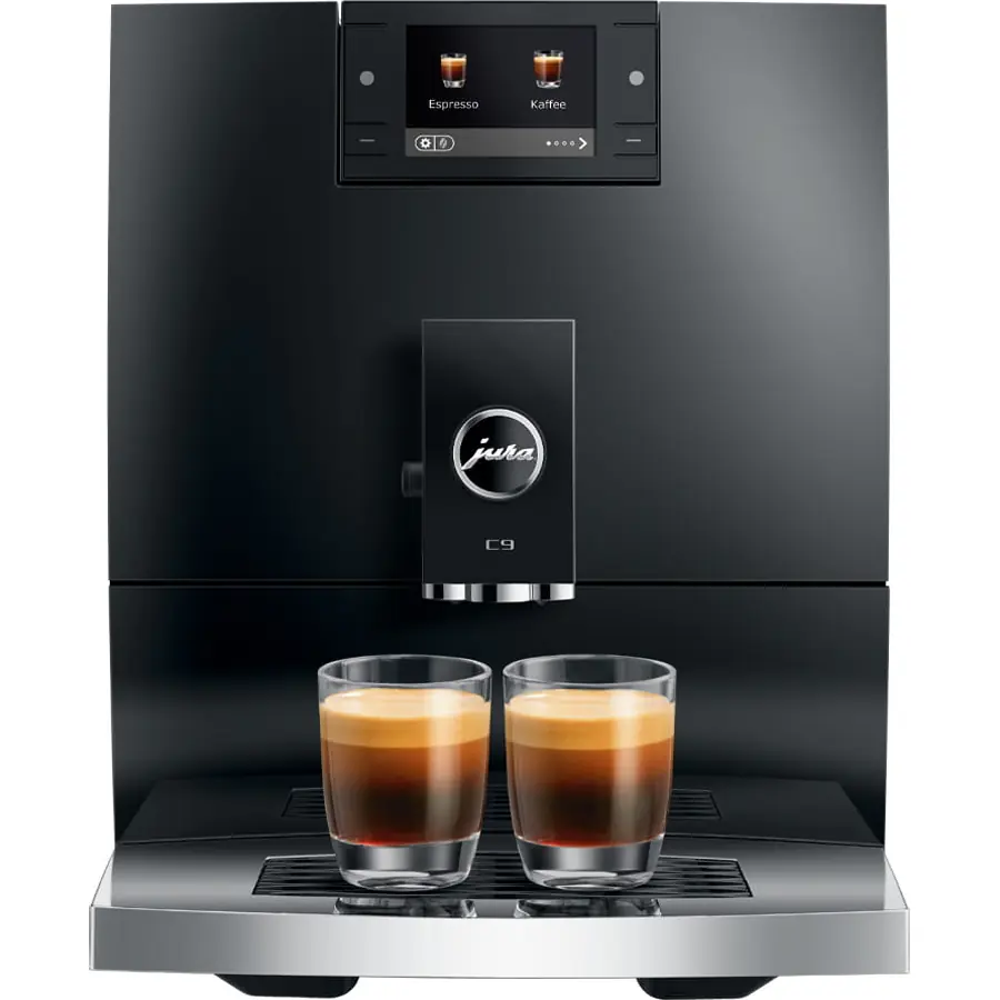 A Jura C9 Super-Automatic Espresso Machine in black has two espresso cups filled with coffee on its drip tray, while the digital display shows options for Espresso and Kaffee.