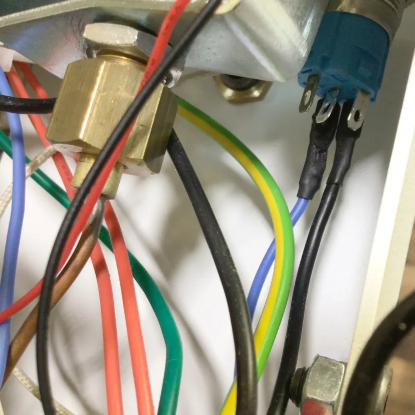 Close-up view of electrical wiring inside a Nurri R-Type device, showing multiple colored wires (red, yellow, green, blue, black, brown) connected to terminals and a metallic Dual Boiler component.