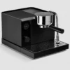 The Fellow Espresso Series 1 Espresso Machine, featuring a digital display, round portafilter handle, and metal steam wand, rests on a perforated drip tray against a light gray background.