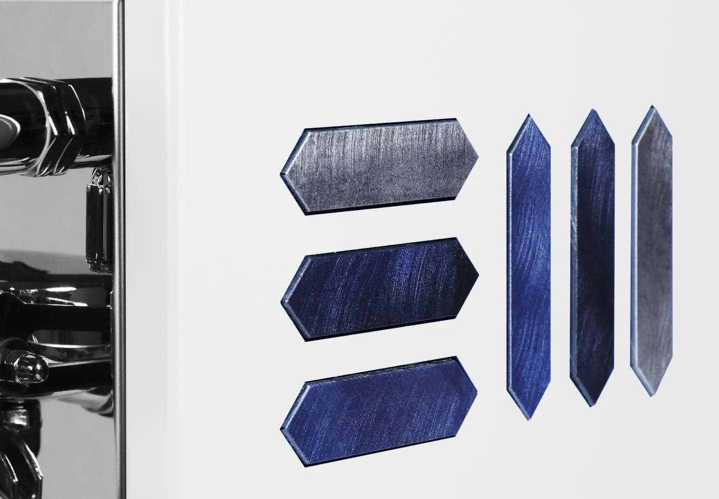 Close-up of Torre Peppina Luxury Build: white surface features three horizontal, arrow-shaped dark blue inlays on the left and three vertical inlays on the right; polished chrome hardware adds a refined touch.