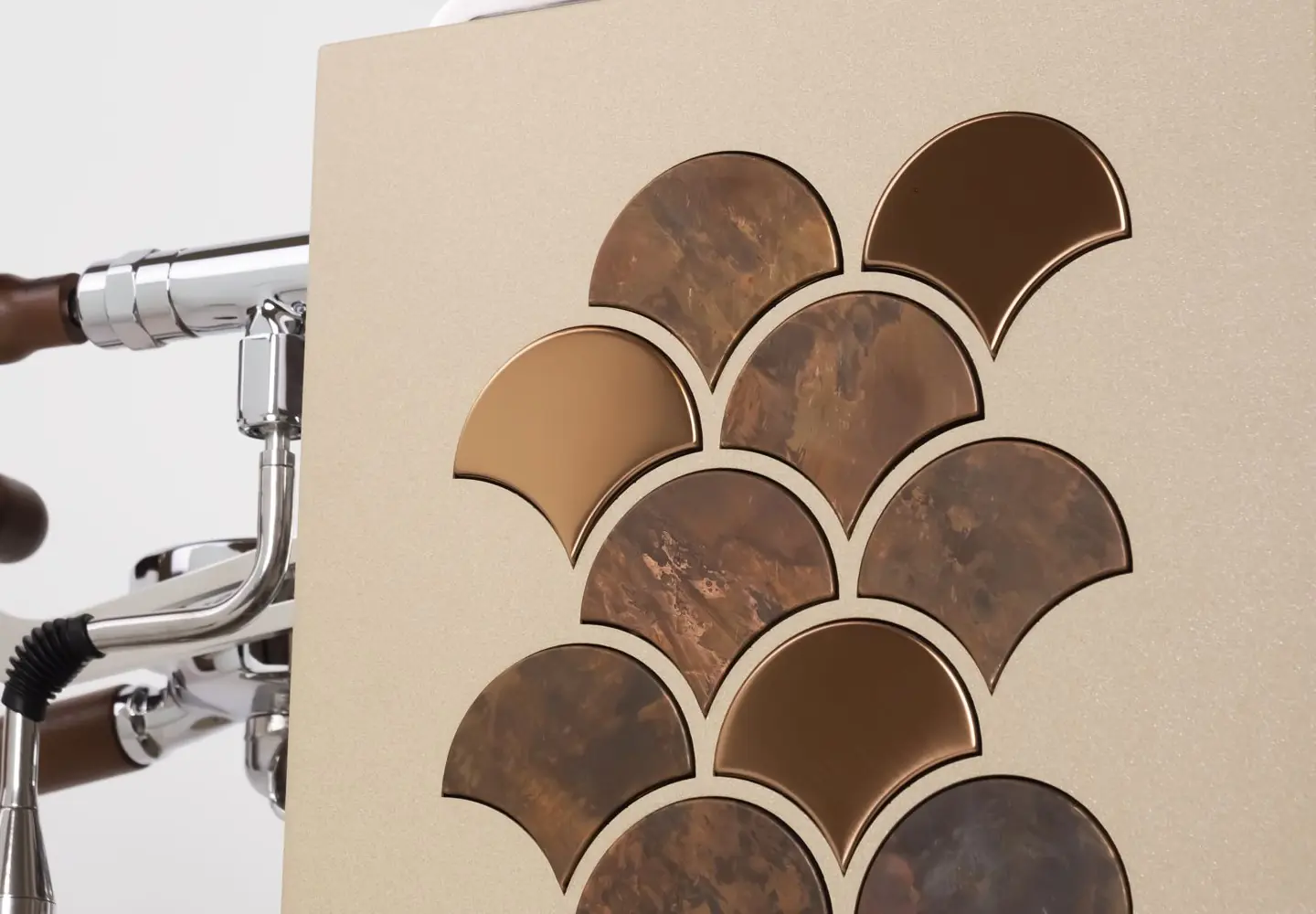 Close-up of the Torre Peppina Luxury Build coffee machine panel with a beige surface, overlapping fan-shaped brown and bronze inlays, chrome accents, and a wooden handle, showcasing exclusive design details.