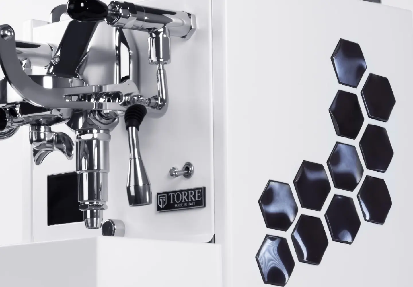 Close-up of the Torre Peppina Luxury Build espresso machine with chrome accents, black hexagonal side designs, and a "Made in Italy" label on the front.
