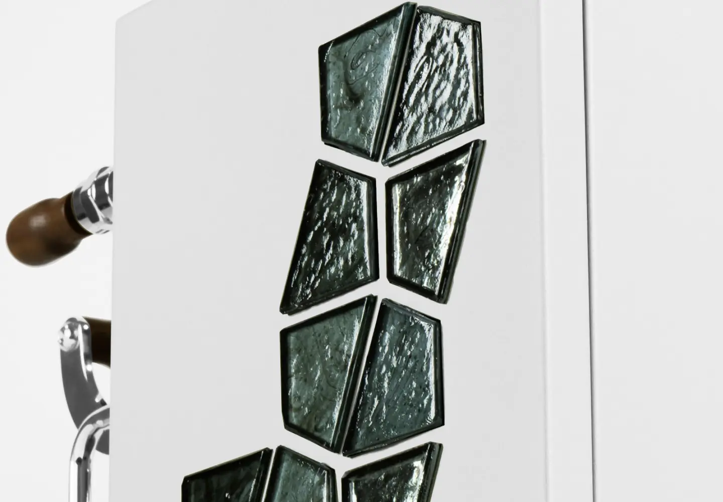 A white panel from the Torre Peppina Luxury Build showcases vertical dark green geometric glass accents; a metal handle with a wooden grip appears partially on the left side.