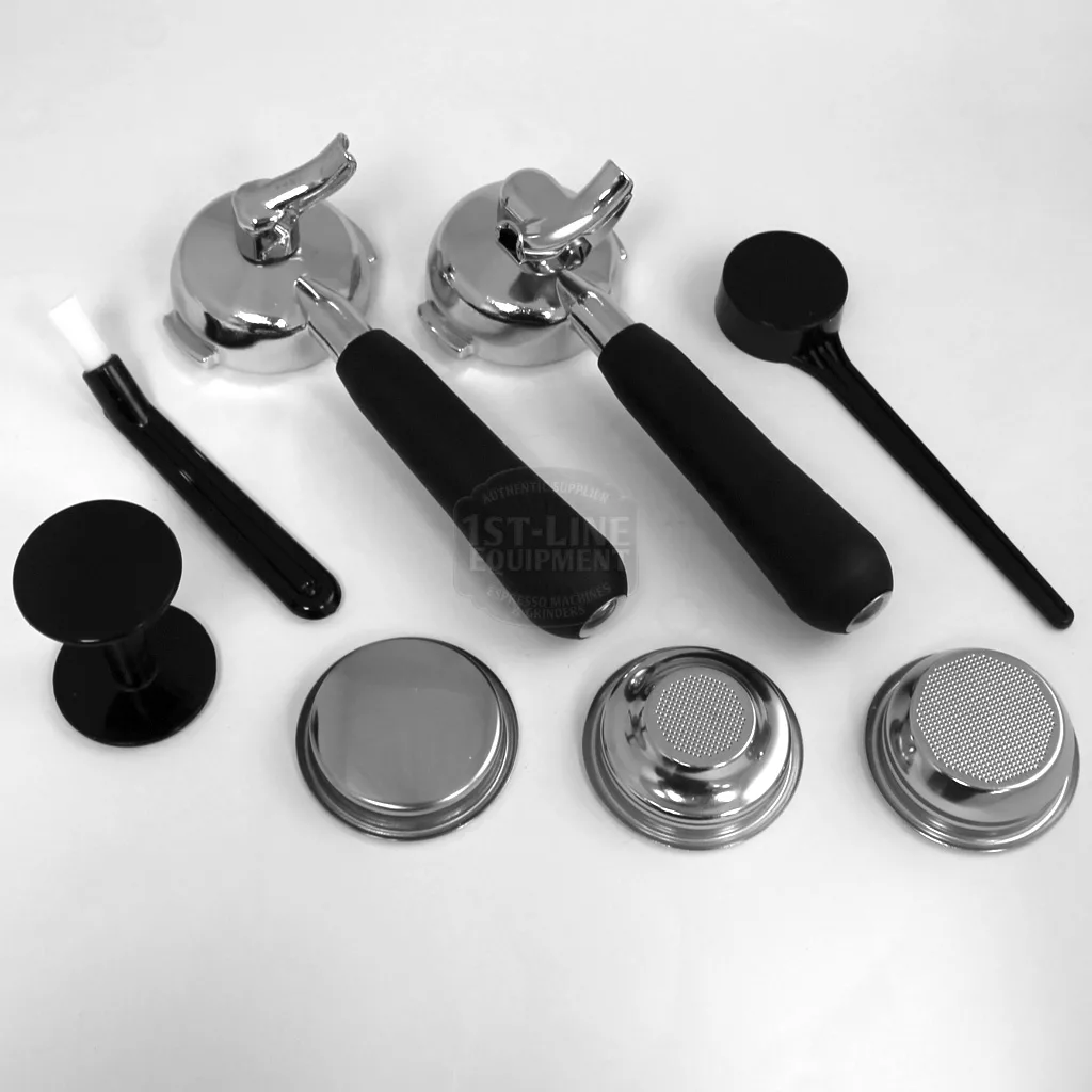A set of espresso machine accessories on a white surface—including portafilters, tampers, a cleaning brush, a blind filter, and filter baskets—ideal for the DISCONTINUED VBM Domobar Junior HX Espresso Machine. © 2025 1st-line.com