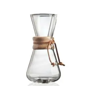 A clear glass Chemex coffee maker with a wooden collar and leather tie around its narrow waist—an elegant choice for coffee lovers or as one of the perfect college graduation gifts—set against a white background.