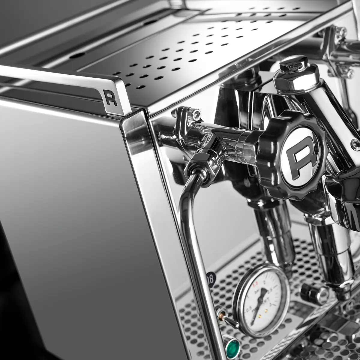 Close-up of a polished Rocket R Cinquantotto (R58) Dual Boiler Espresso Machine featuring stainless steel surfaces, pressure gauge, and knobs, with the “R” logo on both side and front. The machine boasts a modern, professional design.