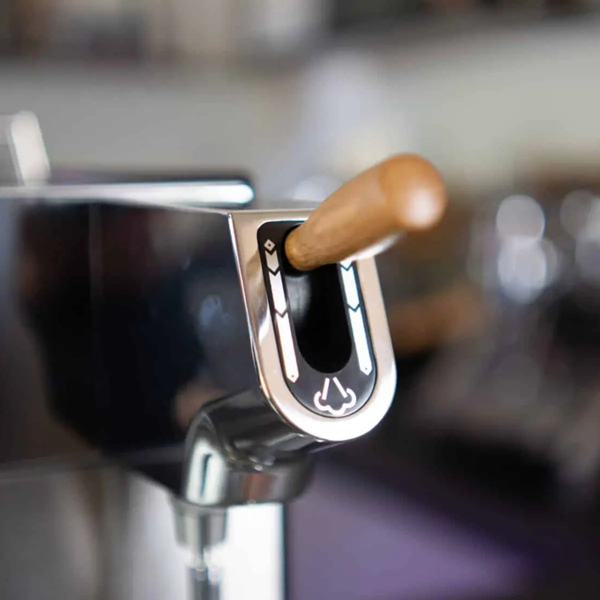 Close-up of a wooden-handled lever on the Elektra Evok 2 Group Commercial Espresso Machine, engraved with steam and water symbols, set against a softly blurred background. 2025 1st-line.com
