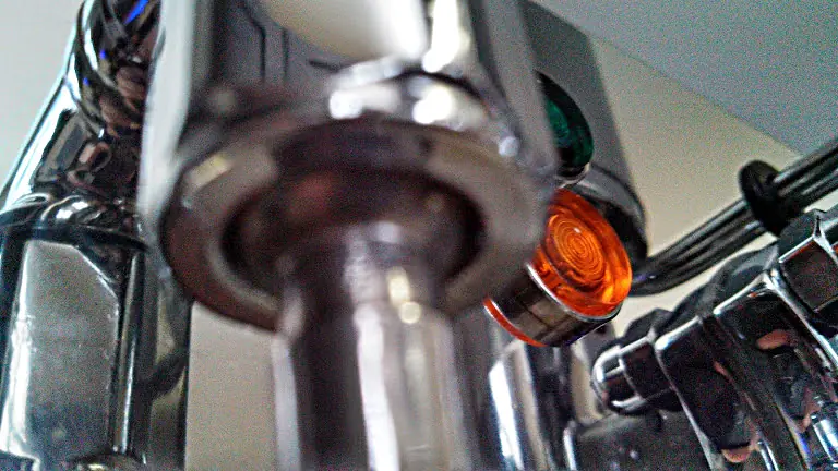 Close-up of a shiny metallic Strega espresso machine, focusing on the spout with illuminated orange and green indicator lights in the background—ideal for spotting any potential steam valve leak. 2025 1st-line.com