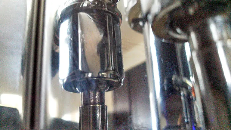 Close-up of a shiny metal part, possibly a piston or steam valve leak, with reflective surfaces and blurred background, evoking the precision of Strega machinery or mechanical equipment. 2025 1st-line.com