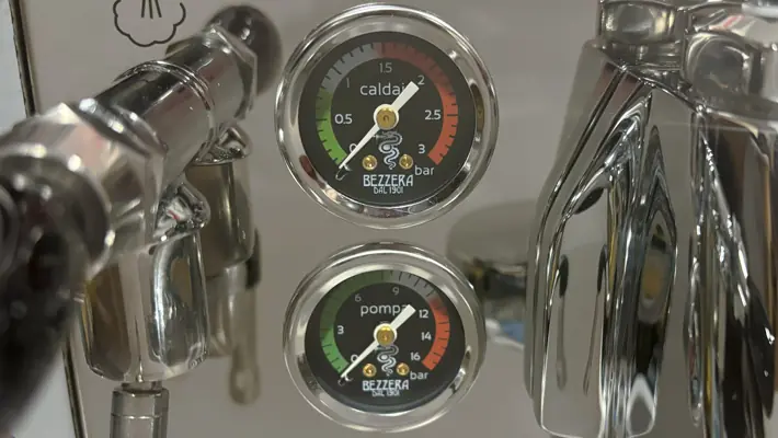 Close-up of two pressure gauges on the Bezzera Sole PID HX Espresso Machine. The upper gauge is labeled caldaia, the lower pompa—both have colored bar indicators and clear glass covers.