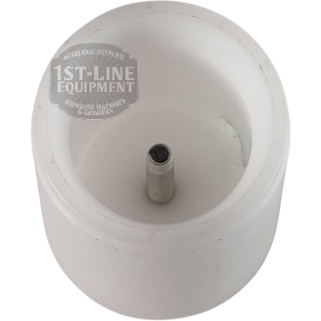 A white cylindrical plastic part with a central metal rod, identified as the Torre RACCS004 Tank Connection Female Fitting, is photographed from above. Part of "1st-Line Equipment Espresso Machines & Grinders" text appears on the side.