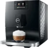A Jura C9 Super-Automatic Espresso Machine brews a cappuccino, filling a clear glass with coffee topped by frothy milk on the drip tray.